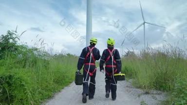 两名从事<strong>安全</strong>设备维修工作的工程师步行到风力涡轮机前，检查风力涡轮机的运行情况，清洁能源概念，可再生能源，拯救世界.